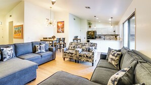 Una sala moderna con sofá, sillón y comedor.