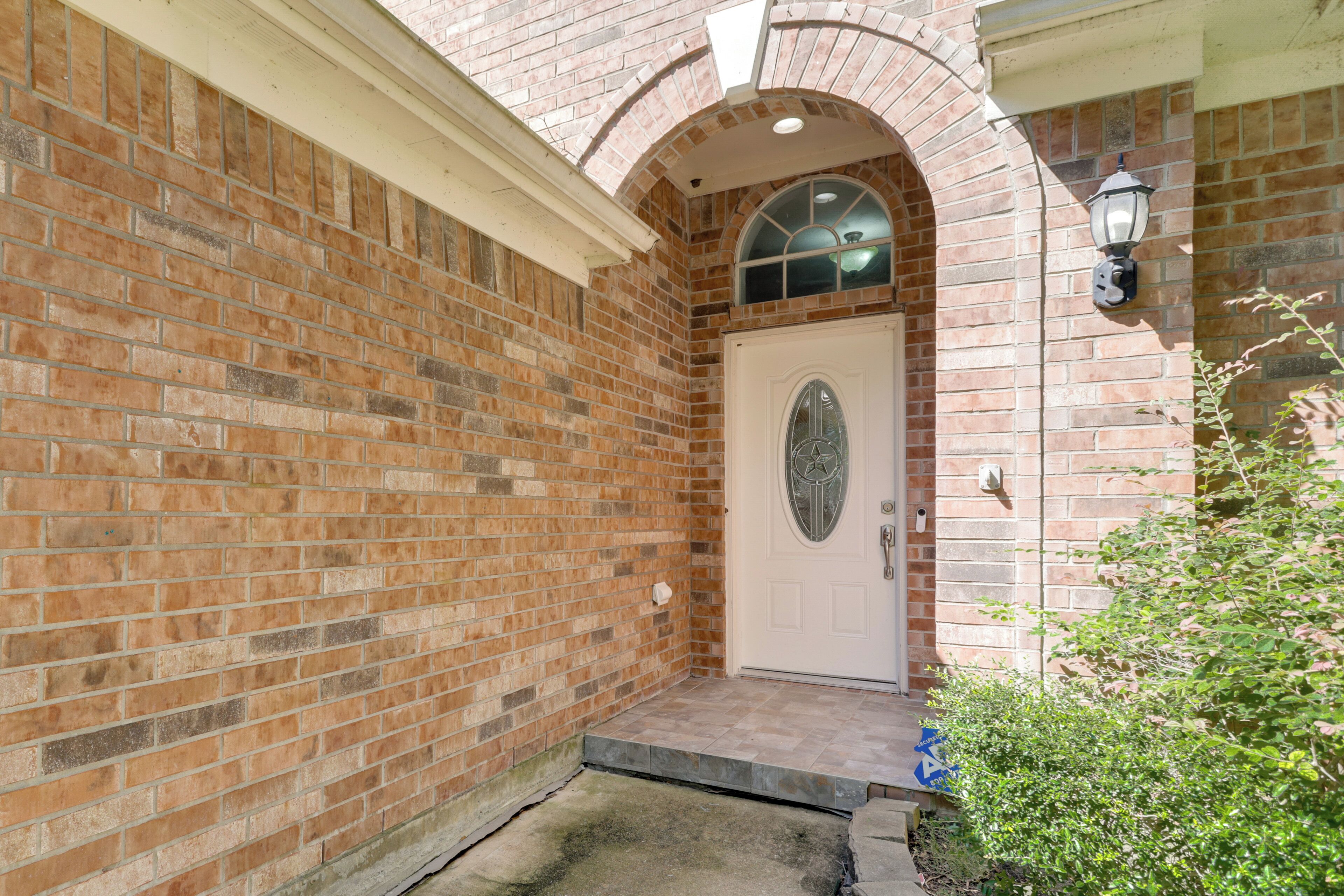 A brick building with a white door and a small porch.