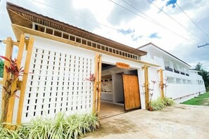 A modern building with a white facade, a wooden entrance gate, and a visible balcony. - Holabay Resort (Panglao)