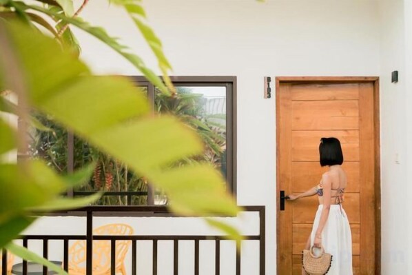 A person opening a wooden door with a metal handle. - Holabay Resort (Panglao)