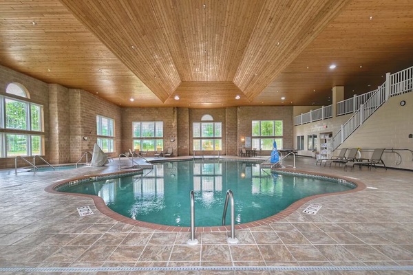 Dive into a sunlit indoor pool under warm timber ceilings.