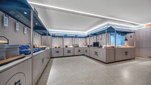 A modern, spacious kitchen area with multiple counters and food display cases, featuring clear signage for different food categories. - hantingjiudian (Qingdao)