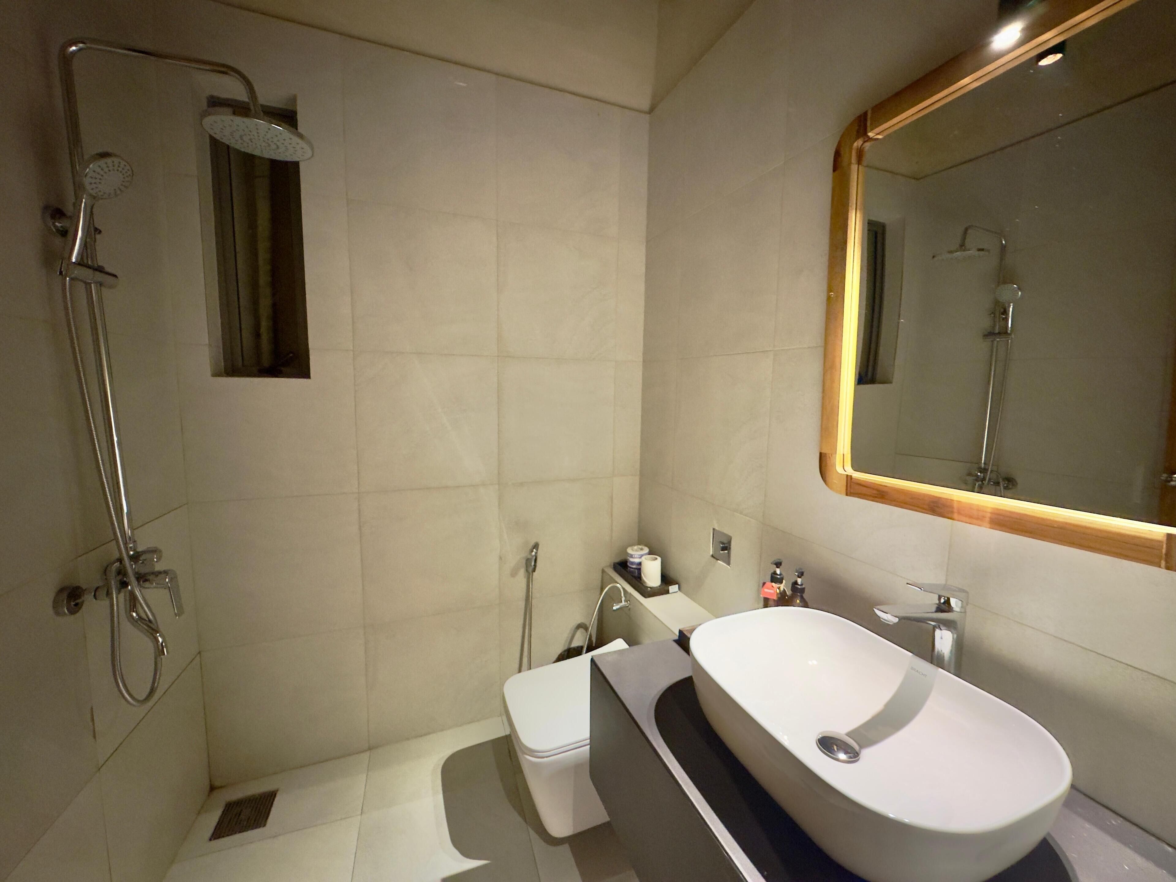 A modern bathroom with a shower, toilet, and sink.
