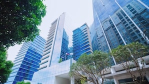 Un hôtel moderne doté d’une façade en verre, de plusieurs étages et d’un espace d’entrée abrité.