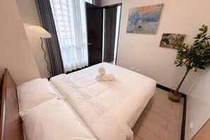A hotel room with a bed, a potted plant, and artwork on the wall. - WY Suites (Lapu-Lapu City)