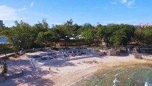 Une plage avec des transats, un rivage sablonneux et une eau cristalline.