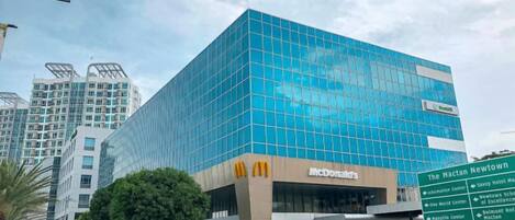 Ein modernes Gebäude mit Glasfassade und einem McDonald's-Schild, umgeben von städtischer Infrastruktur.