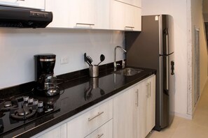 Geladeira, cafeteira/chaleira, talheres/pratos/utensílios de cozinha