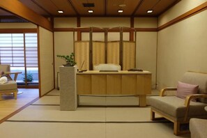 A traditional Japanese-style room with tatami flooring, a reception desk, a sofa, and sliding doors. - Takanawa Hanakohro, a Member of Small Luxury Hotels of the World (Tokyo)