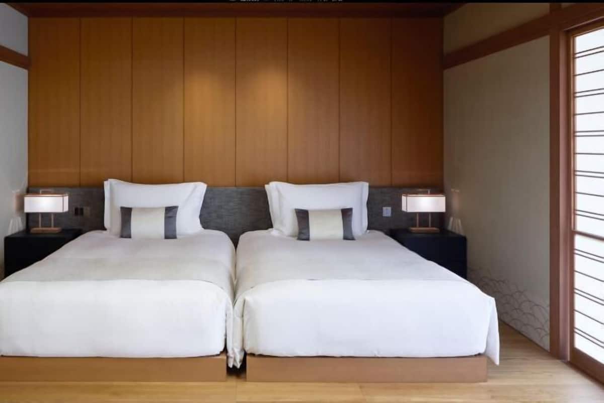 A double bed with white bedding and two bedside tables with lamps.