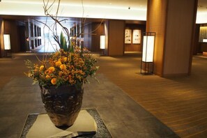 A lobby with a large potted plant, a reception desk, and a framed artwork on the wall. - Takanawa Hanakohro, a Member of Small Luxury Hotels of the World (Tokyo)