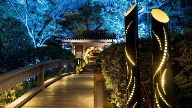 A pathway leading to a traditional building with a wooden bridge and illuminated decorations. - Takanawa Hanakohro, a Member of Small Luxury Hotels of the World (Tokyo)