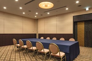 Ein Konferenzraum mit einem langen Tisch, Stühlen und Teppichboden.