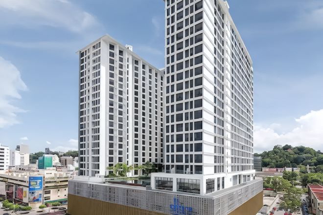 A high-rise building with a modern architectural design, featuring a grid-like facade and multiple floors.