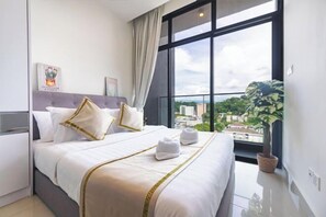 Ein Hotelzimmer mit einem großen Bett, Blick auf die Stadt und einer Zimmerpflanze.