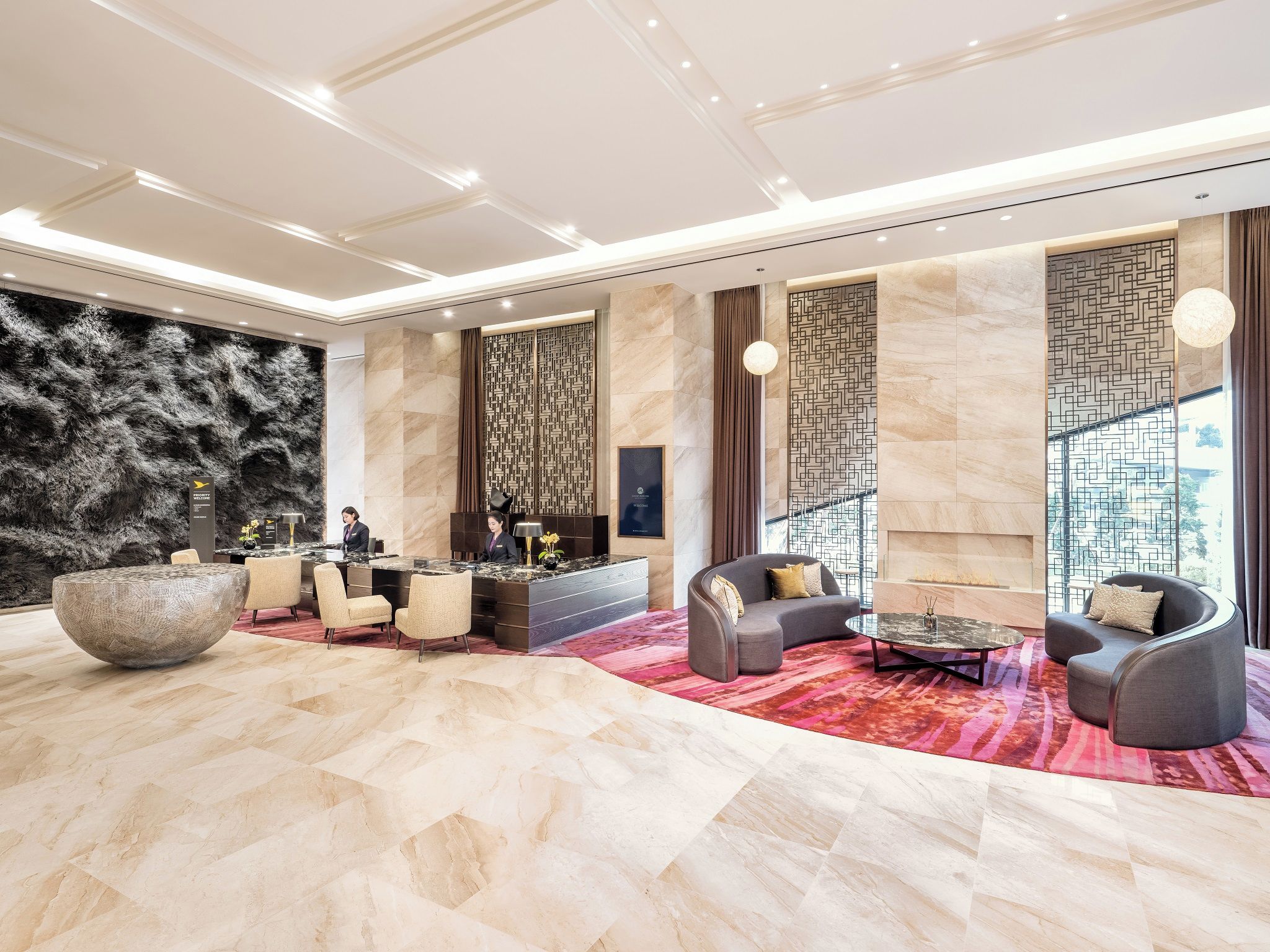 A spacious lobby with a reception desk, seating area, and a large decorative bowl.