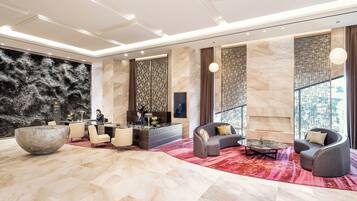 A spacious lobby with a reception desk, seating area, and a large decorative bowl.