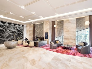 Eine großzügige Lobby mit einer Rezeption, einer Sitzecke und einer großen Dekorationsschale.