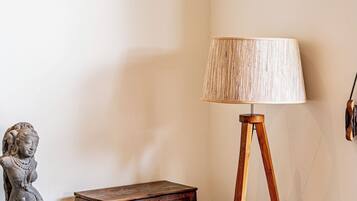 A room with a wooden floor lamp, a statue, and a wooden chest.