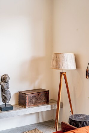 A room with a wooden floor lamp, a statue, and a wooden chest. - Casa Nyang Uluwatu (Pecatu)