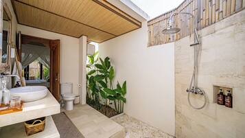 Un baño moderno con un lavamanos grande, inodoro y zona de ducha.