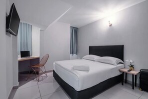 A modern hotel room with a large bed, a desk with a computer, a chair, and a TV mounted on the wall. - Hako Xpress Tampoi (Johor Bahru)