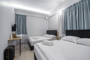 A hotel room with two beds, a desk with a laptop, a chair, a suitcase, and a TV on the wall. - Hako Xpress Tampoi (Johor Bahru)
