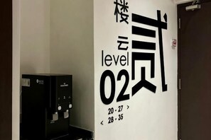 Una pared con texto negro grande que indica 'level 02' y una máquina de café a la izquierda.