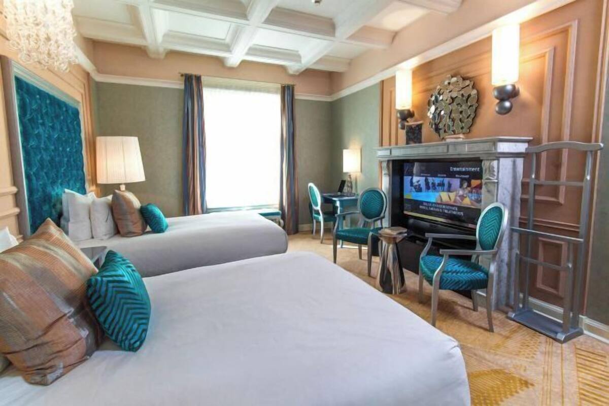 Ett hotellrum med två sängar, en TV, ett skrivbord och en stol.