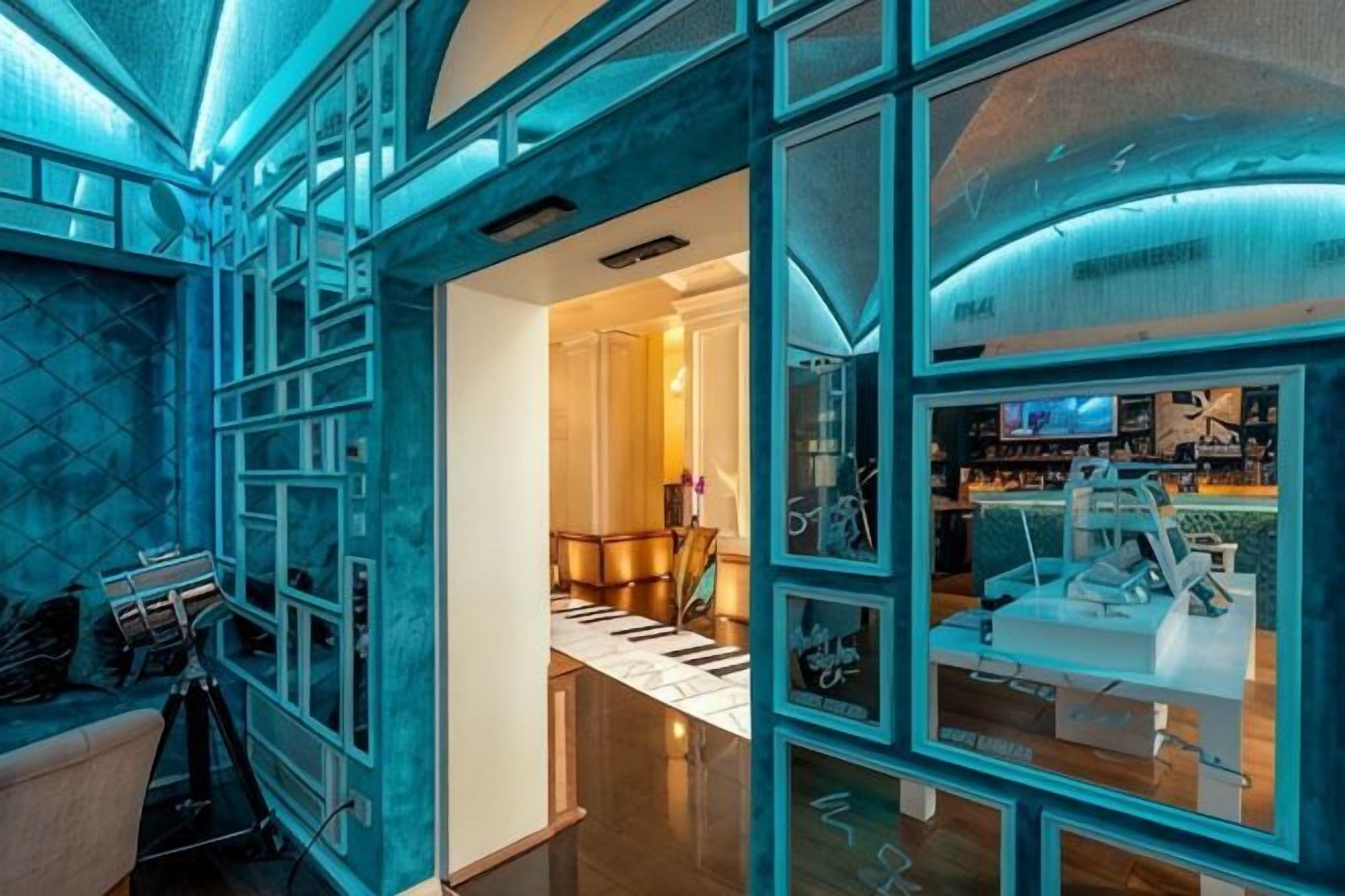A modern interior with a glass partition, a reception desk, and a view of the lobby area.