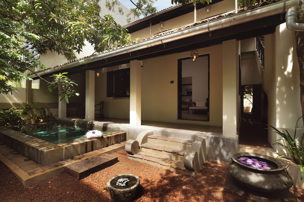 A spa area with a hot tub, stone steps, and a flower arrangement.