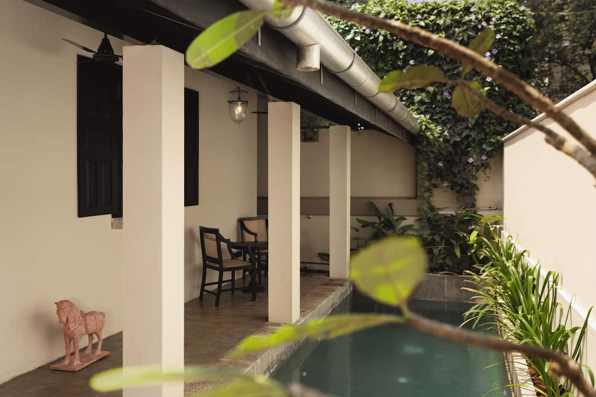 A pool area with a dining setup and a statue.
