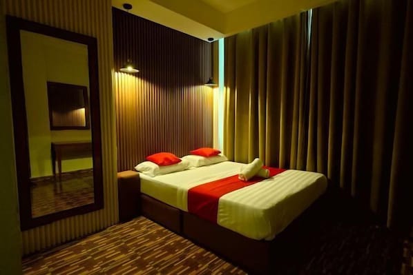 Une chambre d’hôtel avec un lit, un miroir et un mur recouvert de panneaux en bois.