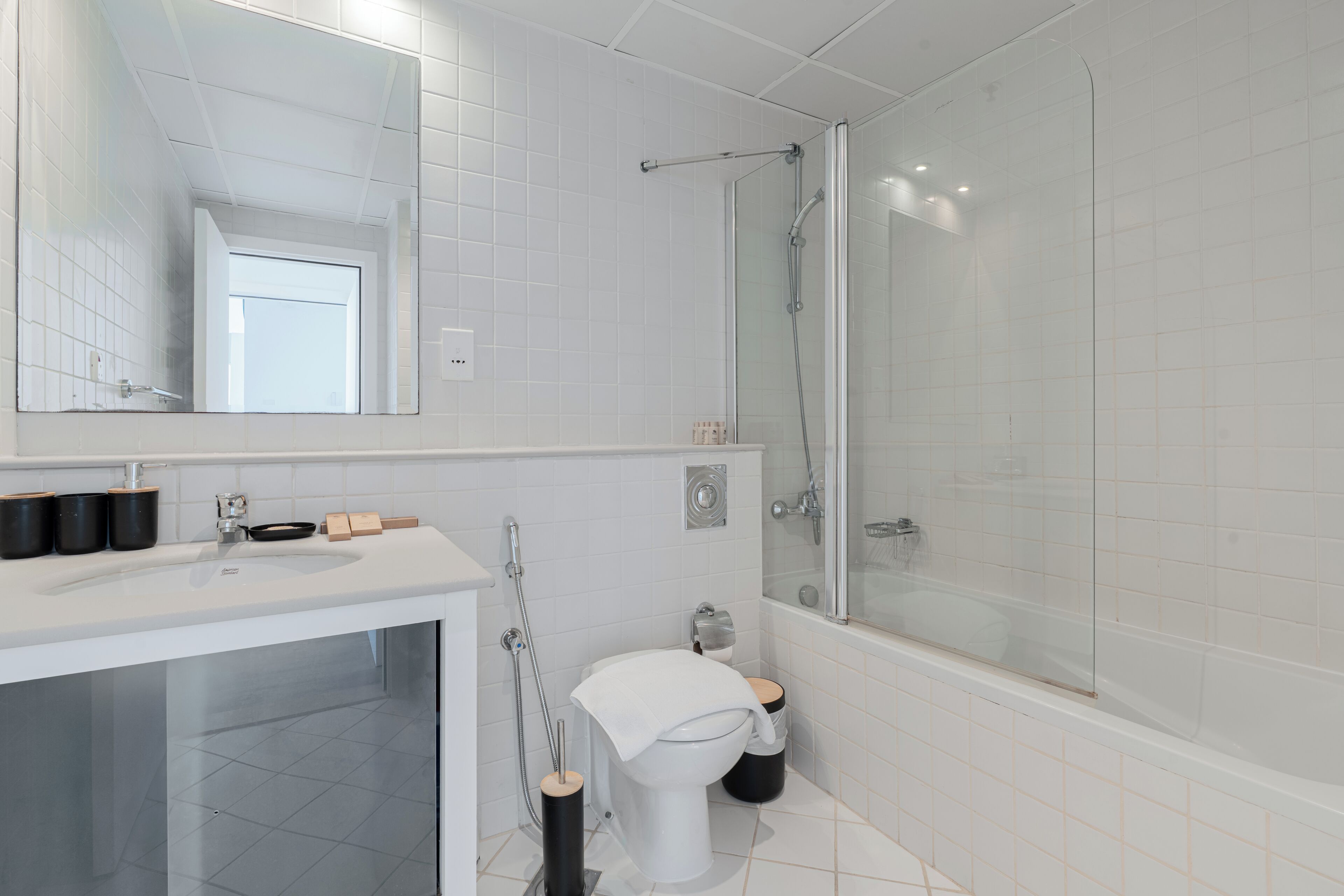 A modern bathroom with a white sink, toilet, and bathtub.