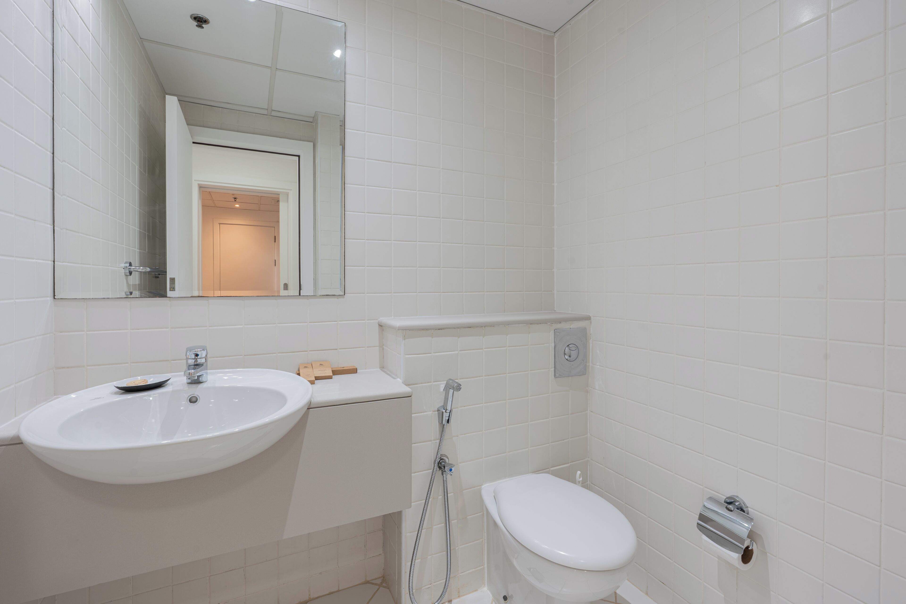 Un baño con lavamanos, inodoro y ducha blancos.