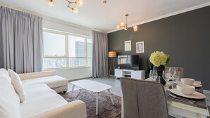 A modern living room with a sofa, coffee table, and dining area set. - Marina Quays Residences - Dubai Marina (Dubai)