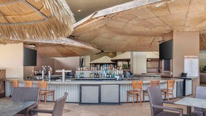 Een bar met een toonbank, barkrukken en parasols.