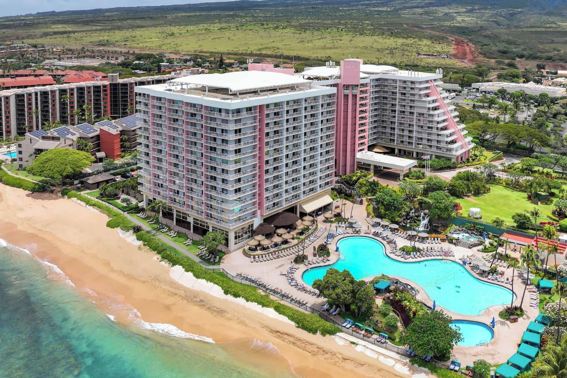 Ein Hochhaus-Hotel mit mehreren Stockwerken, einem Poolbereich und einer Strandlage.