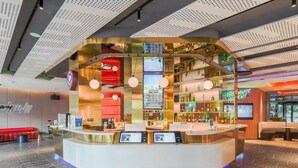 A modern reception area with a curved counter, digital screens, and a bar area. - YIBISI (Qingdao)