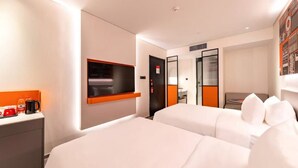 A hotel room with two beds, a desk with a coffee maker, a TV, and a bookshelf. - YIBISI (Qingdao)
