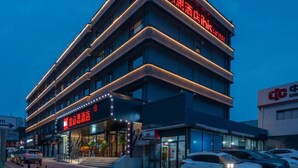 A multi-story hotel with a prominent red sign indicating it is a hotel. - YIBISI (Qingdao)