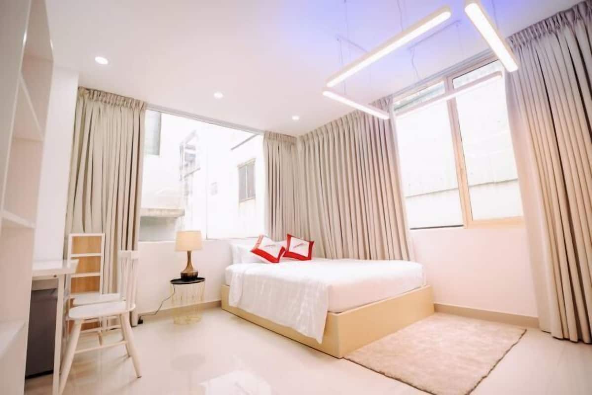 A modern bedroom with a bed, a desk, and a chair.