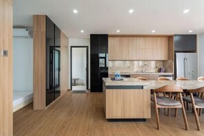 Une cuisine moderne avec des meubles en bois, un îlot central et un coin repas avec des chaises.