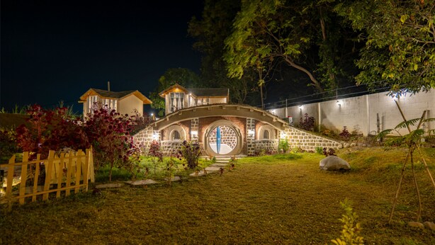 A house with a unique circular window and a bridge leading to it.