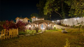 Una casa con una finestra circolare particolare e un ponte che vi conduce.