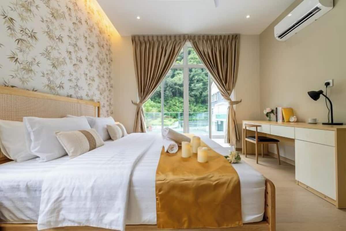 A bedroom with a bed, bedside table, and a desk with a chair.