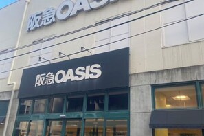 Ein Gebäude mit einem Schild, auf dem 'OASIS' in Englisch und einer anderen Sprache steht.