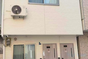 A building with two doors, an air conditioning unit, and a window. - Yodogawa Flower Private Accommodation (Osaka)