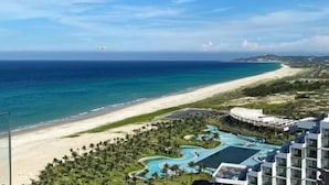 A resort with a beach view, a swimming pool, and a golf course. - Signature Beach at The Arena Cam Ranh (Cam Ranh)