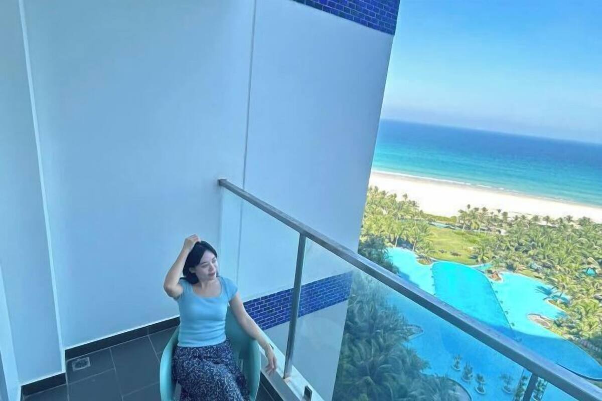 A balcony with a view of a beach and a pool.